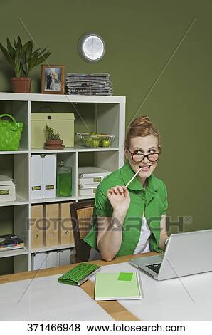 Businesswoman working on a laptop in the office View Large Photo Image Stock Photo - Businesswoman working on a laptop in the office. Fotosearch