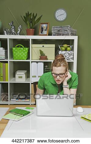 Businesswoman working on a laptop in the office View Large Photo Image Stock Photo - Businesswoman working on a laptop in the office. Fotosearch