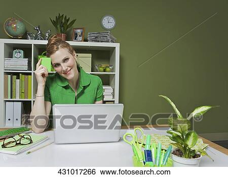 Businesswoman working on a laptop in the office View Large Photo Image Stock Photograph - Businesswoman working on a laptop in the office. Fotosearch