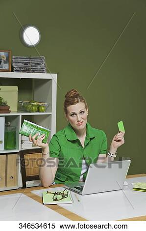 Businesswoman working on a laptop in the office and holding a credit card View Large Photo Image Stock Photography - Businesswoman working on a laptop in the office and holding a credit card. Fotosearch