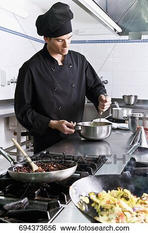 Chef cooking food in the kitchen View Large Photo Image Stock Photograph - Chef cooking food in the kitchen. Fotosearch
