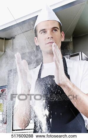 Stock Photo - Chef dusting hands with flour. Fotosearch