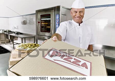 Stock Image - Chef holding a pizza box. Fotosearch