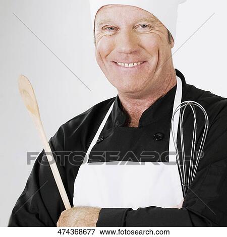 Chef holding a wooden spoon and a wire whisk View Large Photo Image Stock Photo - Chef holding a wooden spoon and a wire whisk. Fotosearch
