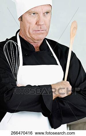 Chef holding a wooden spoon and a wire whisk View Large Photo Image Stock Photograph - Chef holding a wooden spoon and a wire whisk. Fotosearch
