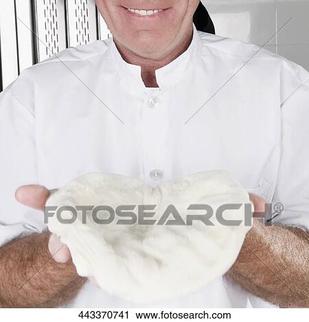 Stock Image - Chef holding pizza dough. Fotosearch