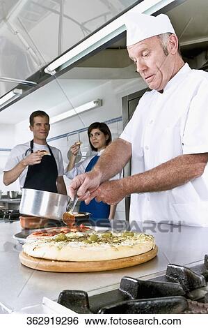 Chef preparing pizza in the kitchen View Large Photo Image Stock Photograph - Chef preparing pizza in the kitchen. Fotosearch