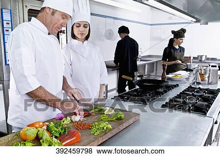 Chefs cooking food in the kitchen View Large Photo Image Stock Photo - Chefs cooking food in the kitchen. Fotosearch
