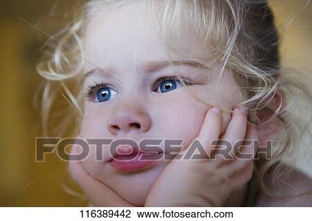 Stock Image - Close-up of a baby girl thinking. Fotosearch