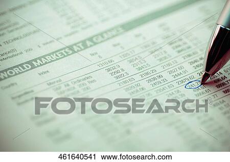 Stock Image - Close-up of a ball point pen marking on a financial newspaper. Fotosearch