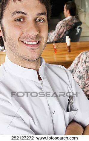 Stock Image - Close-up of a barber smiling. Fotosearch