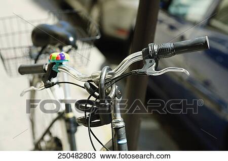 Close-up of a bicycle locked to a pole View Large Photo Image Stock Image - Close-up of a bicycle locked to a pole. Fotosearch