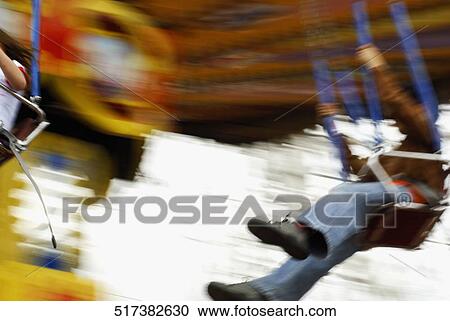 Close-up of a boy and a girl swinging on a chain swing View Large Photo Image Stock Image - Close-up of a boy and a girl swinging on a chain swing. Fotosearch