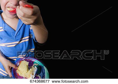 Close-up of a boy eating cake View Large Photo Image Stock Photo - Close-up of a boy eating cake. Fotosearch