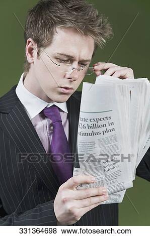 Stock Photo - Close-up of a businessman reading a newspaper. Fotosearch