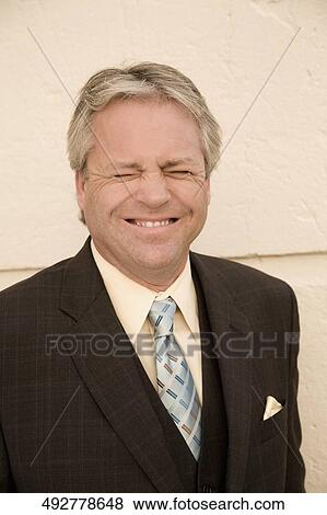 Stock Photo - Close-up of a businessman smiling with his eyes closed, Biltmore Hotel, Coral Gables, Florida, USA. Fotosearch