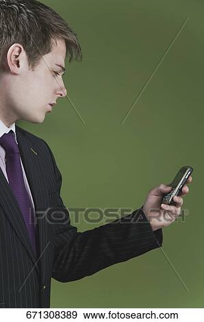Stock Photo - Close-up of a businessman text messaging on a mobile phone. Fotosearch