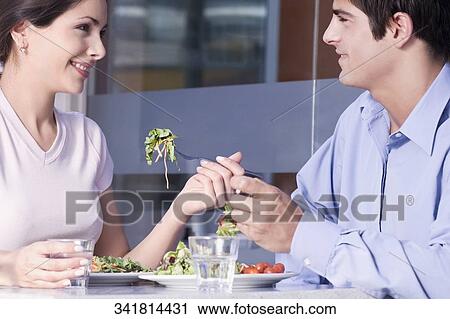 Close-up of a couple eating salad in a restaurant View Large Photo Image Stock Image - Close-up of a couple eating salad in a restaurant. Fotosearch
