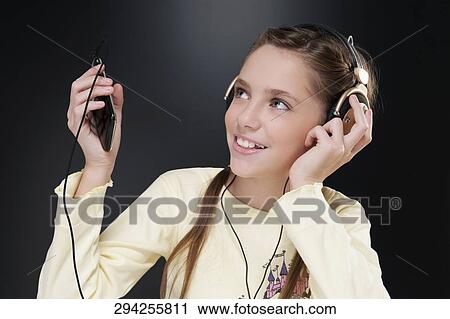 Close-up of a girl listening to music View Large Photo Image Stock Image - Close-up of a girl listening to music. Fotosearch