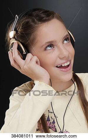 Close-up of a girl listening to music View Large Photo Image Stock Image - Close-up of a girl listening to music. Fotosearch