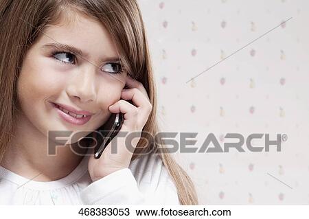 Close-up of a girl talking on a mobile phone View Large Photo Image Stock Image - Close-up of a girl talking on a mobile phone. Fotosearch