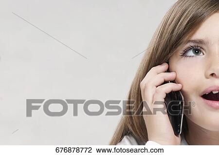 Close-up of a girl talking on a mobile phone View Large Photo Image Stock Image - Close-up of a girl talking on a mobile phone. Fotosearch