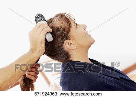 Close-up of a hairdresser's hand combing a mature woman's hair View Large Photo Image Stock Image - Close-up of a hairdresser's hand combing a mature woman's hair. Fotosearch