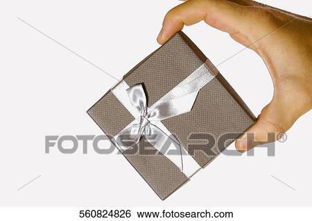 Close-up of a human hand holding a gift View Large Photo Image Stock Photograph - Close-up of a human hand holding a gift. Fotosearch