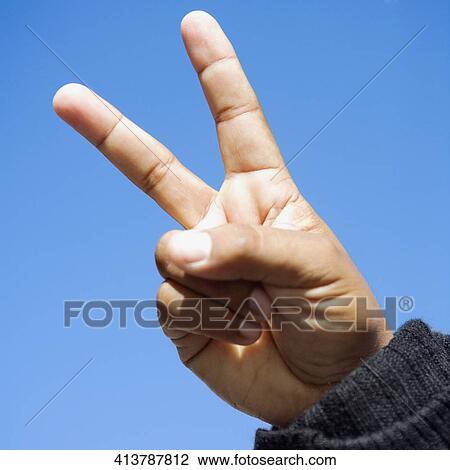 Stock Image - Close-up of a human hand with a peace sign. Fotosearch