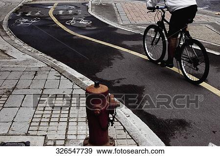 Close-up of a hydrant with a person cycling beside it View Large Photo Image Stock Photo - Close-up of a hydrant with a person cycling beside it. Fotosearch