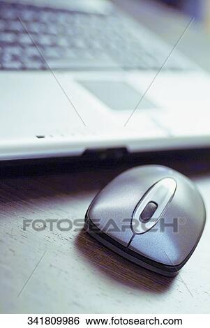 Close-up of a laptop with a computer mouse View Large Photo Image Stock Photograph - Close-up of a laptop with a computer mouse. Fotosearch