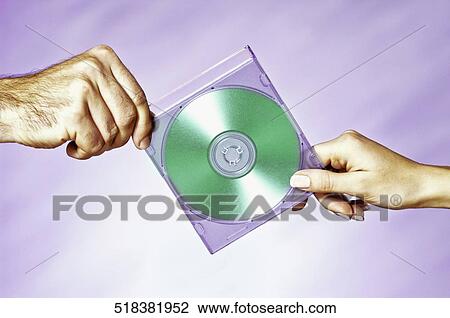Stock Image - Close-up of a man and a woman holding a compact disc. Fotosearch