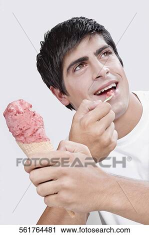 Close-up of a man eating an ice cream View Large Photo Image Stock Image - Close-up of a man eating an ice cream. Fotosearch