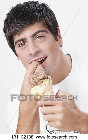 Close-up of a man eating an ice cream View Large Photo Image Stock Photo - Close-up of a man eating an ice cream. Fotosearch