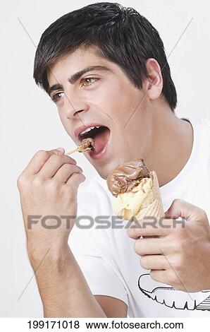 Close-up of a man eating an ice cream View Large Photo Image Stock Photo - Close-up of a man eating an ice cream. Fotosearch