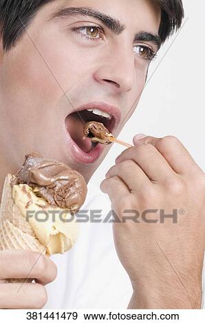 Stock Photo - Close-up of a man eating an ice cream. Fotosearch