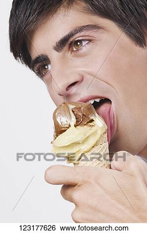 Stock Photograph - Close-up of a man eating an ice cream. Fotosearch