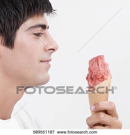 Close-up of a man holding an ice cream View Large Photo Image Stock Photo - Close-up of a man holding an ice cream. Fotosearch