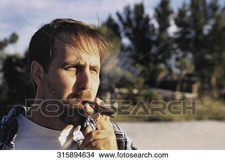 Close-up of a man smoking a cigar View Large Photo Image Picture - Close-up of a man smoking a cigar. Fotosearch