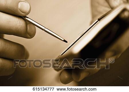 Close-up of a man's hand using a personal data assistant View Large Photo Image Stock Photo - Close-up of a man's hand using a personal data assistant. Fotosearch