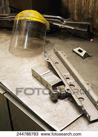 Close-up of a metal object and a helmet visor on a workbench View Large Photo Image Stock Image - Close-up of a metal object and a helmet visor on a workbench. Fotosearch