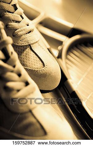 Stock Photo - Close-up of a pair of shoes and a tennis racket. Fotosearch