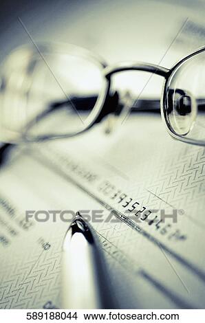 Close-up of a pen and eyeglasses on a check View Large Photo Image Picture - Close-up of a pen and eyeglasses on a check. Fotosearch