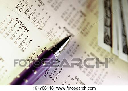 Close-up of a pen and paper currency on a calendar View Large Photo Image Stock Photo - Close-up of a pen and paper currency on a calendar. Fotosearch
