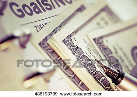 Close-up of a pen and US paper currency on a personal organizer View Large Photo Image Stock Photo - Close-up of a pen and US paper currency on a personal organizer. Fotosearch