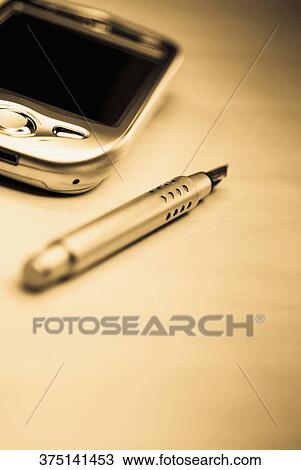 Stock Image - Close-up of a personal data assistant with a fountain pen. Fotosearch