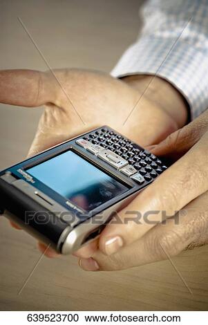 Close-up of a person's hand holding a smart phone View Large Photo Image Stock Image - Close-up of a person's hand holding a smart phone. Fotosearch