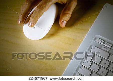 Stock Photo - Close-up of a person's hand holding a computer mouse. Fotosearch