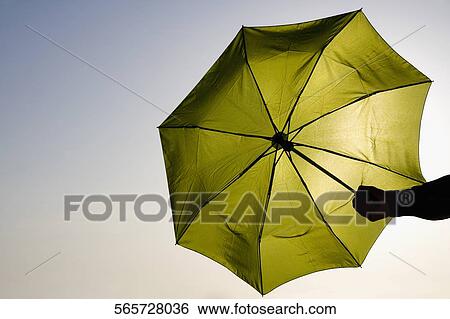 Stock Photograph - Close-up of a person's hand holding an umbrella. Fotosearch