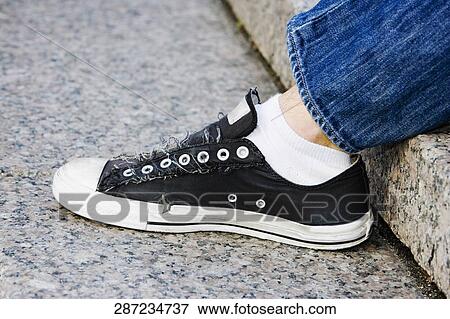 Close-up of a person's leg with a sneaker View Large Photo Image Stock Photo - Close-up of a person's leg with a sneaker. Fotosearch